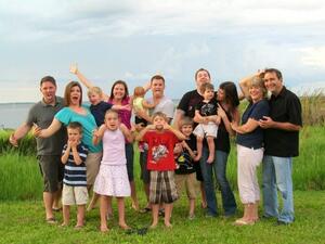 large family of adults and children smiling excitedly